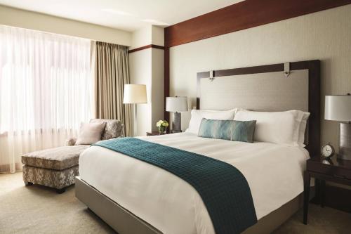 a hotel room with a large bed and a chair at The Ritz-Carlton Georgetown, Washington, D.C. in Washington