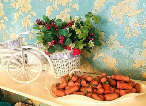 a plate of carrots on a table with a vase of flowers at Гостиничный комплекс Жеты Казына in Zharkent