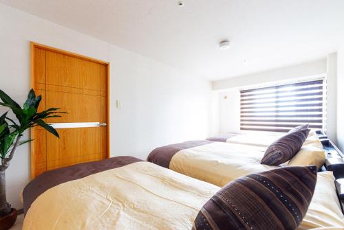 een slaapkamer met 2 bedden en een raam bij PRIME in Sapporo