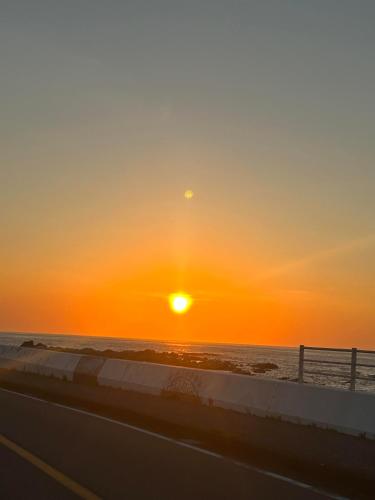 a sunset over the ocean and a highway at South coast Chikura in Chikura