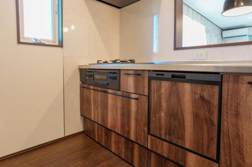 a kitchen with wooden cabinets and a counter top at South coast Chikura in Chikura
