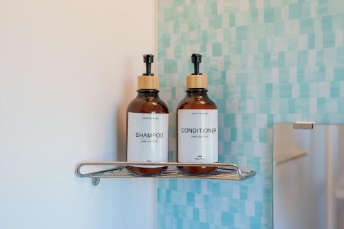two bottles of soap and sunglasses on a shelf in a bathroom at South coast Chikura in Chikura