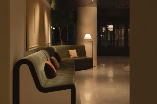 a living room with a couch and a lamp at Amid Hotel Seoul in Seoul