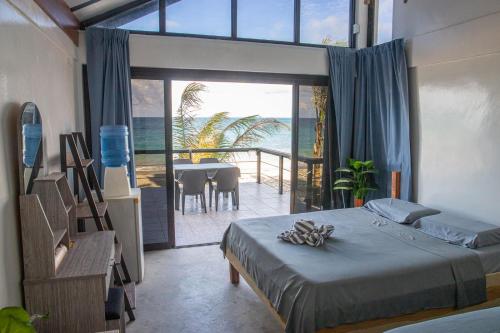 a bedroom with a bed and a view of the ocean at Surigao Dream Beach Resort in Tigbao