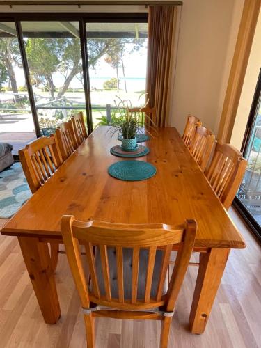 a wooden dining room table with chairs and a plant on it at Pav's Place in American River