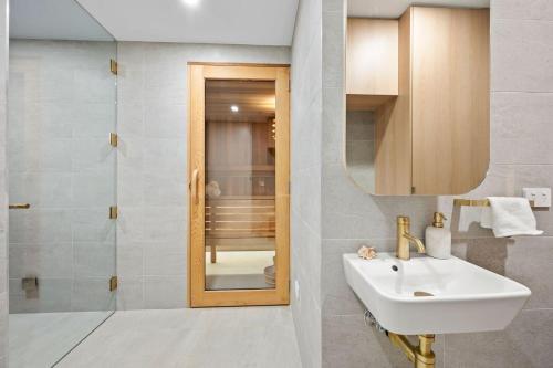 Un baño con lavabo, espejo y ducha. en Casa Lux, en Aireys Inlet