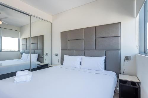 a bedroom with two beds and a large mirror at Comfort Two bedroom Apartment with Free parking In Valley in Brisbane