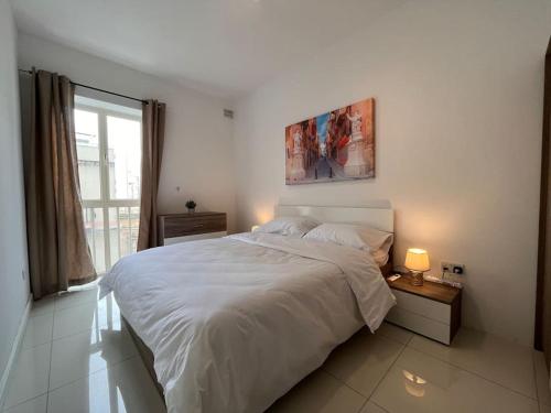 Un dormitorio blanco con una cama grande y una ventana en Cosy 2Bedroom 1 min walk away from the sea apartment 1, en Il-Gżira