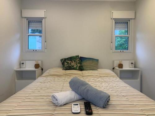 a bedroom with a bed with two remote controls on it at Destino26 Hostel in Montevideo