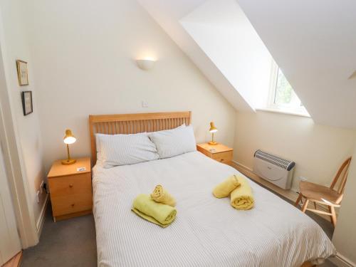 Somerford Keynes的住宿－Kingfisher House，一间卧室配有一张黄色毛巾的床