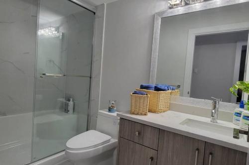a bathroom with a toilet and a shower and a sink at Lucy's Place - Two Bedroom Suite in Vancouver
