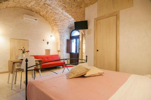 um quarto com uma cama e um quarto com um sofá em Dammuso Romantico em Scicli
