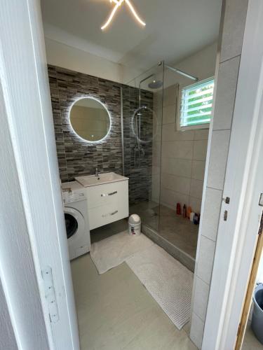 un bagno con doccia e lavatrice di Attrapes rêves a Saint-François