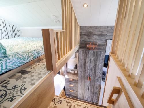 Zimmer mit einem Bett und einer Treppe in der Unterkunft Posh Pod in Cemaes Bay