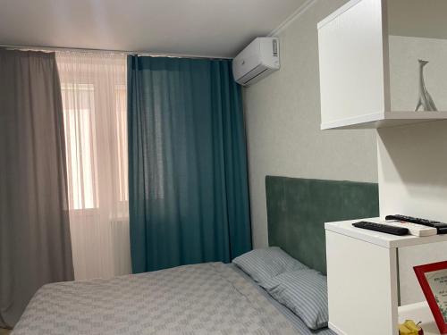 ein Schlafzimmer mit einem Bett und einem grünen Vorhang in der Unterkunft Cozy Apartment Center in Chişinău