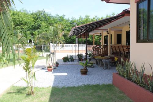 a patio with potted plants and a house at Naluemon Village FH 2 in Ban Phe