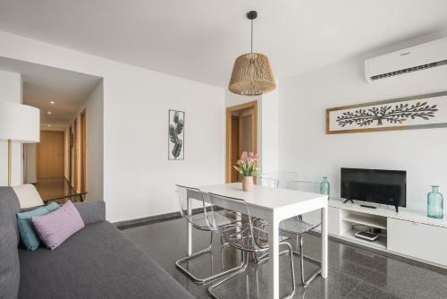 ein Wohnzimmer mit einem weißen Tisch und Stühlen in der Unterkunft Macflats Ciudad de las Ciencias in Valencia