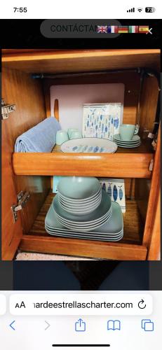 a cabinet with plates and dishes on a shelf at Velero en club náutico valencia mar in Valencia