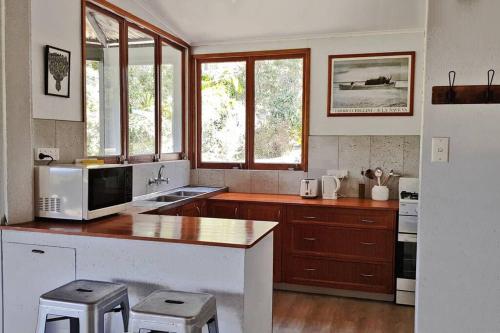 a kitchen with a counter with a microwave and some windows at Wolvi Wonderland - Eco Escape in Wolvi