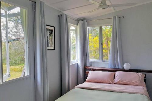 1 dormitorio con 1 cama y 2 ventanas en Wolvi Wonderland - Eco Escape, en Wolvi