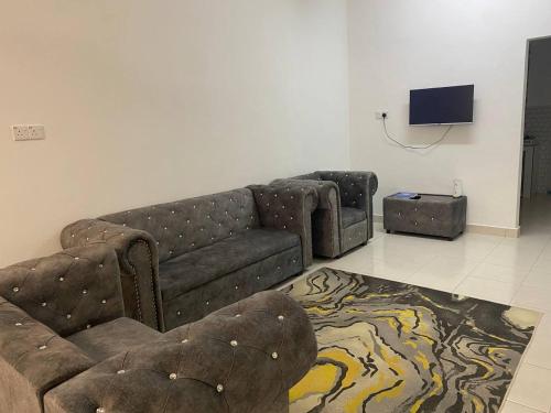 a living room with a couch and a tv at Anak Air Homestay, Serkam Islam Guest Only in Malacca