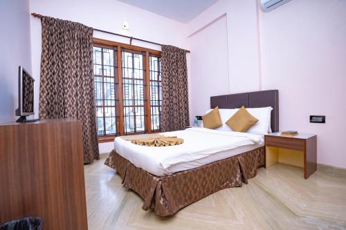 a bedroom with a large bed and a television in it at SS Mystic Apartotel in Bangalore