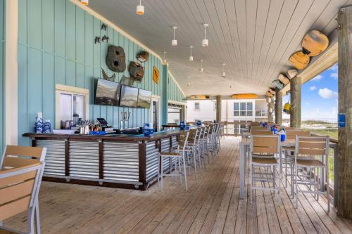 a restaurant with tables and chairs and a bar at Fairfield by Marriott Inn & Suites Pensacola Beach in Pensacola Beach