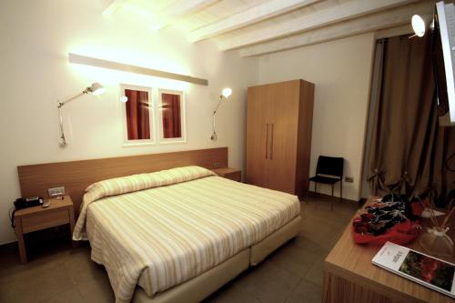 a bedroom with a bed and a desk and a window at San Rocco Hotel in Scanzorosciate