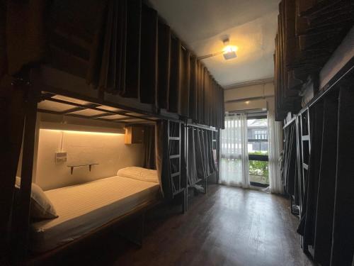 a room with two bunk beds and a window at Hobnob Hostel in Chiang Mai