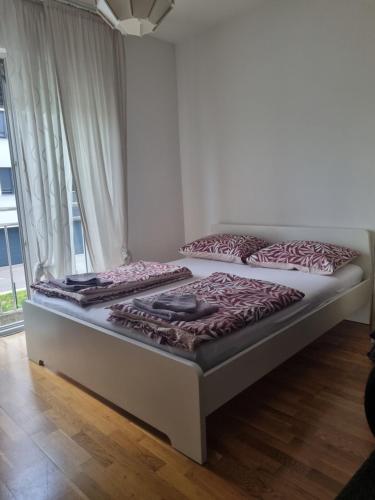 two beds in a room with a window at Apartman Niko in Zagreb