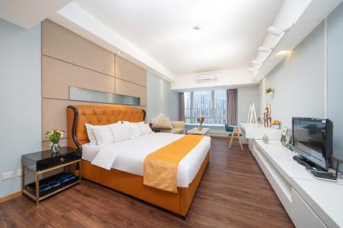 a bedroom with a large bed and a television at Orange Tree International Hotel Zhujiang New Town US Consulate General Guangzhou Branch - Free Shuttle Bus to Canton Fair Complex During Canton Fair Period in Guangzhou
