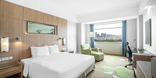 a hotel room with a white bed and a window at Holiday Inn Changzhou Wujin by IHG in Changzhou