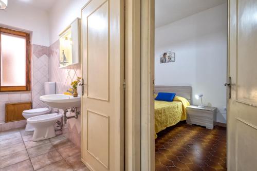 a bathroom with a sink and a toilet and a bed at Isola Rossa - Trilocale Grande in Isola Rossa