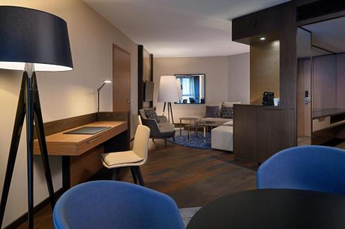 a living room with a room with a couch and a table at Sheraton Grand Tbilisi Metechi Palace in Tbilisi City