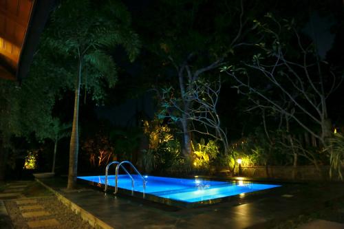 Serene Villa في Hiriketiya: مسبح في الليل مع اضاءة زرقاء