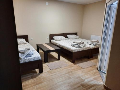 een kamer met twee bedden en een tafel erin bij Mila in Bela Crkva