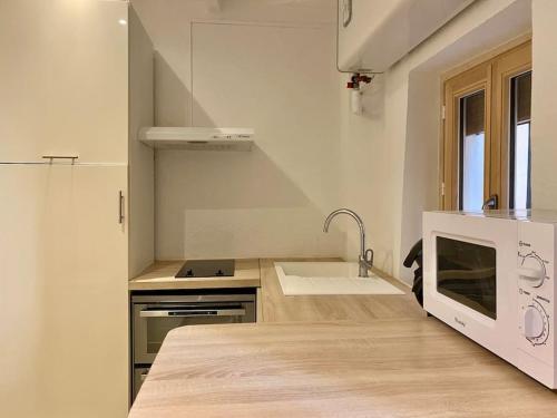 une cuisine blanche avec un évier et une cuisinière dans l'établissement VIEUX-NICE 2 pièces en Duplex, à Nice