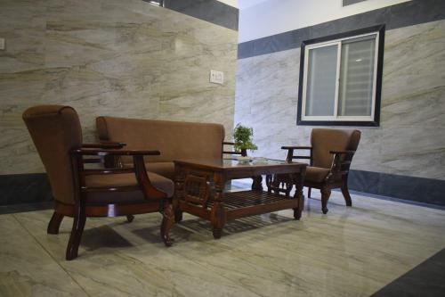 a dining room with chairs and a wooden table at Hotel Lakshya Sheesh Mahal Indore in Indore