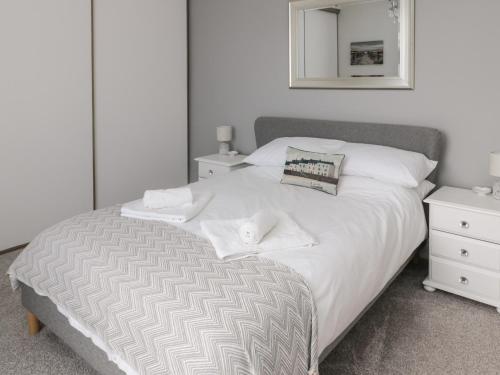 een slaapkamer met een groot wit bed en een spiegel bij 18 Acklington Road in Morpeth