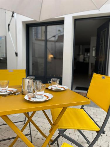 une table jaune avec des assiettes et des verres dans l'établissement L'Archevêché : Au pied de la cathédrale, à Bourges