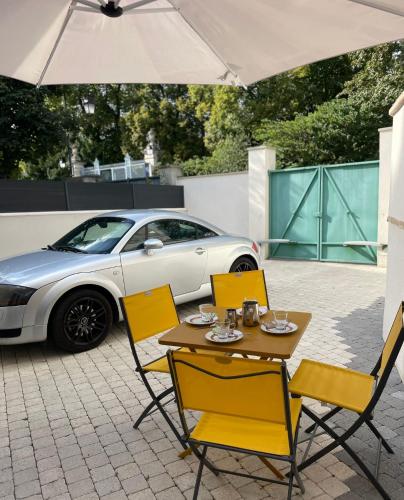 une table et des chaises avec une voiture en arrière-plan dans l'établissement L'Archevêché : Au pied de la cathédrale, à Bourges