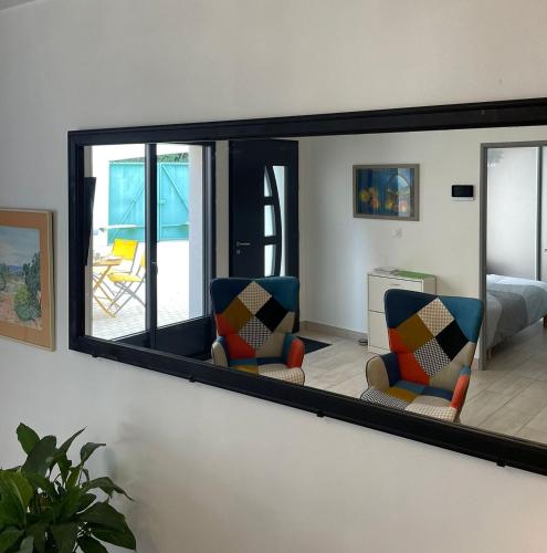 - un miroir mural avec 2 chaises dans la chambre dans l'établissement L'Archevêché : Au pied de la cathédrale, à Bourges