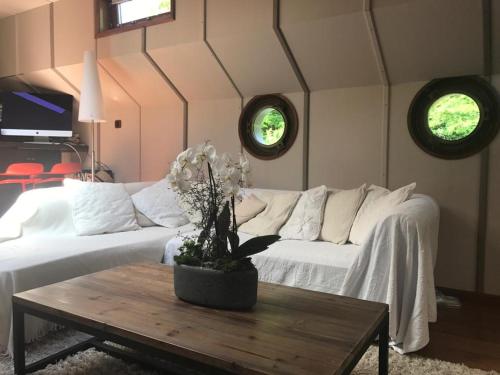 LA PENICHE في كولمار: غرفة معيشة مع أريكة بيضاء وطاولة