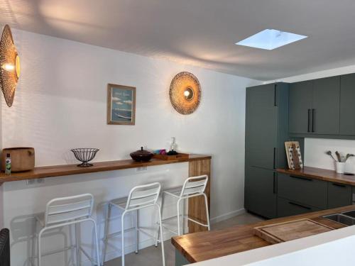 uma cozinha com um balcão e bancos num quarto em Jolie maison Pays d'Aix em Rognes