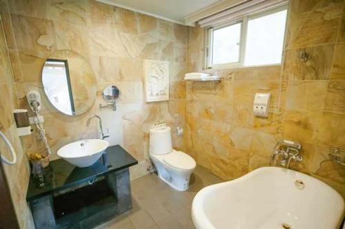 a bathroom with a sink and a tub and a toilet at Green Shine B&B in Nanzhuang