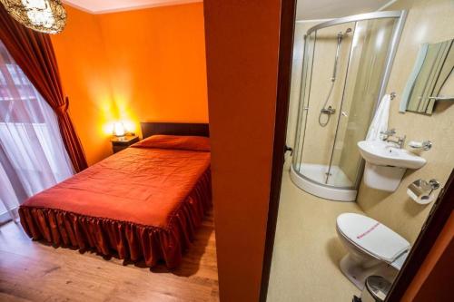 a bedroom with a bed and a bathroom with a sink at Kris Hotel & Restaurant in Smolyan