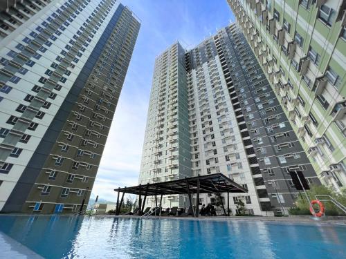 Deux grands bâtiments avec une piscine entre eux dans l'établissement Best inn CEBU Avida Riala Tower 2 716, à Cebu