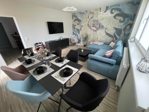 a living room with a table and a blue couch at Stilapartment Oasis 1 #Whirlpool saisonal in Wernigerode