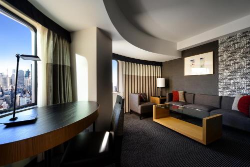 a living room with a couch and a table in a hotel room at Hotel New Otani Tokyo Garden Tower in Tokyo