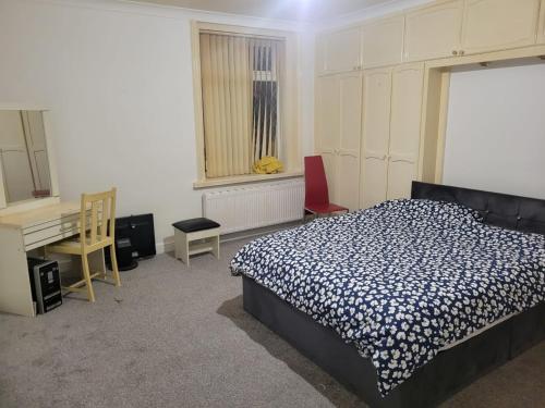 um quarto com uma cama e uma secretária. em Room shared in 3bedroom house in Oldham Manchester em Moorside